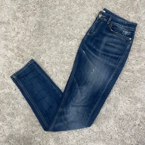 Blå jeans från Dondup - Säljer nu ett par otroligt fräscha Dondup Jeans med extremt snygg fade och slitningar. Inga täcken på användning. Storlek 29. Hör av er vid frågor!
