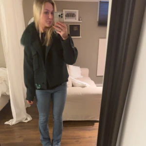 Mörkgrön jacka med pälskrage - Säljer en snygg mörkgrön jacka med pälskrage. Perfekt för höst och vinter. Jackan har långa ärmar och en skön passform. Den är i mycket bra skick och passar perfekt för kyliga dagar.