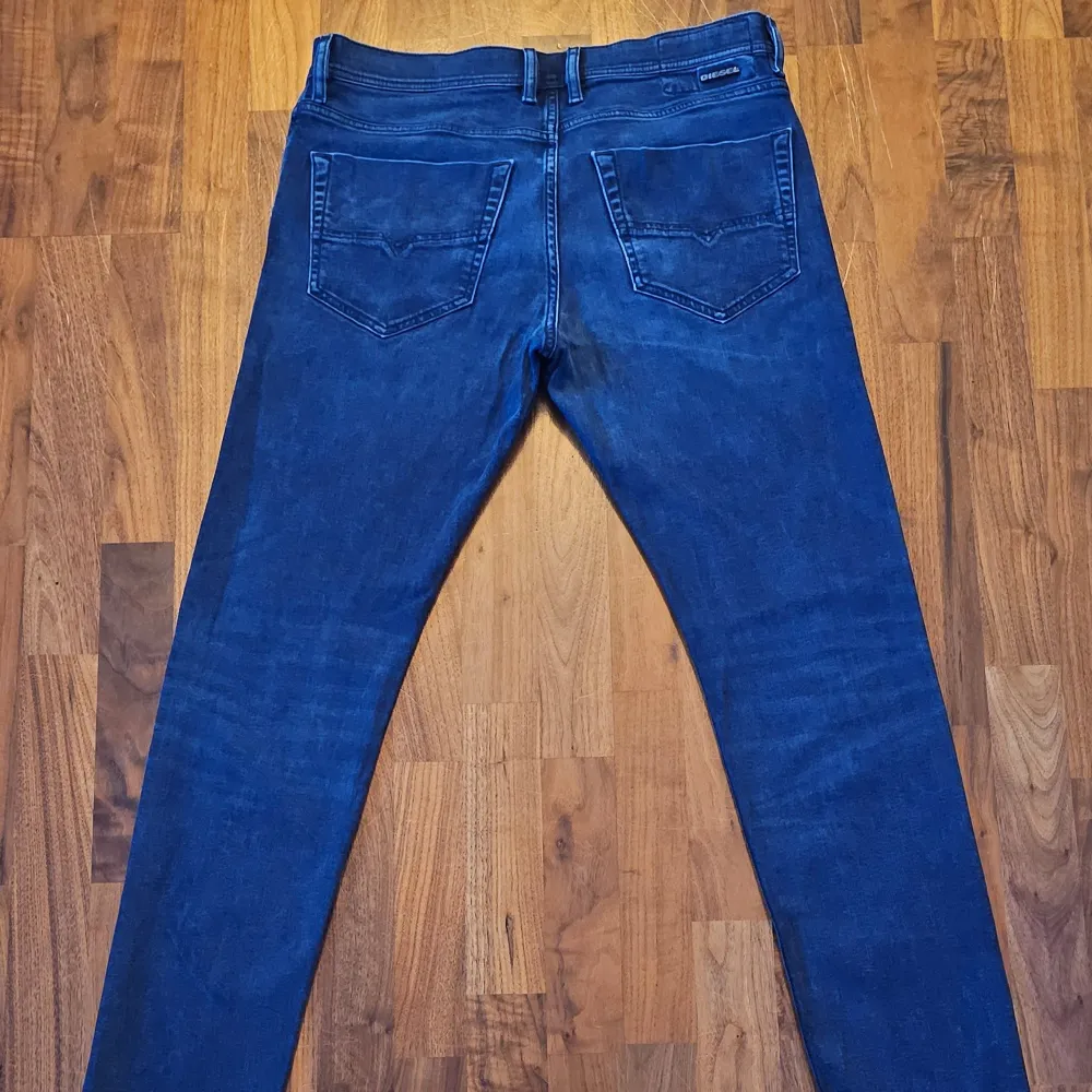 Säljer ett par snygga mörkblå jeans från Diesel, modell Tepphar. De är i bra skick och har en slim passform som sitter perfekt. Materialet är en blandning av bomull och lyocell, vilket gör dem både bekväma och hållbara. Perfekta för både vardag och fest!. Jeans & Byxor.