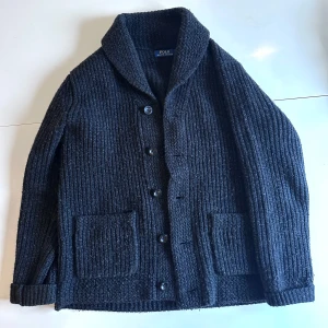 Ralph Lauren Mörkgrå Cardigan - Säljer en snygg mörkgrå stickad cardigan från Ralph Lauren. Haft i en månad, använd kanske fyra gånger, varsamt. Skriv om du har några frågor!