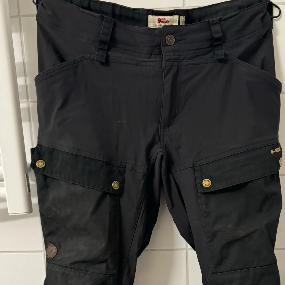 Säljer ett par svarta byxor från Fjällräven i mycket bra skick. Byxorna är i storlek EU 40 med regular benlängd men de är små i storlek så mer som en storlek 38.. Jeans & Byxor.