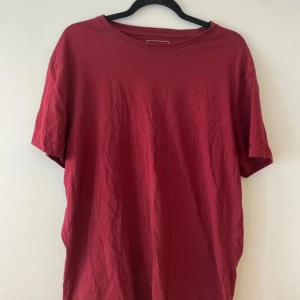 Röd t-shirt från Dressmann - Säljer en röd t-shirt från Dressmann i storlek XL. Den är i bra skick och perfekt för vardagsbruk. T-shirten är kortärmad och gjord av mjuk bomull, vilket gör den bekväm att bära. Passar bra till både jeans och shorts!
