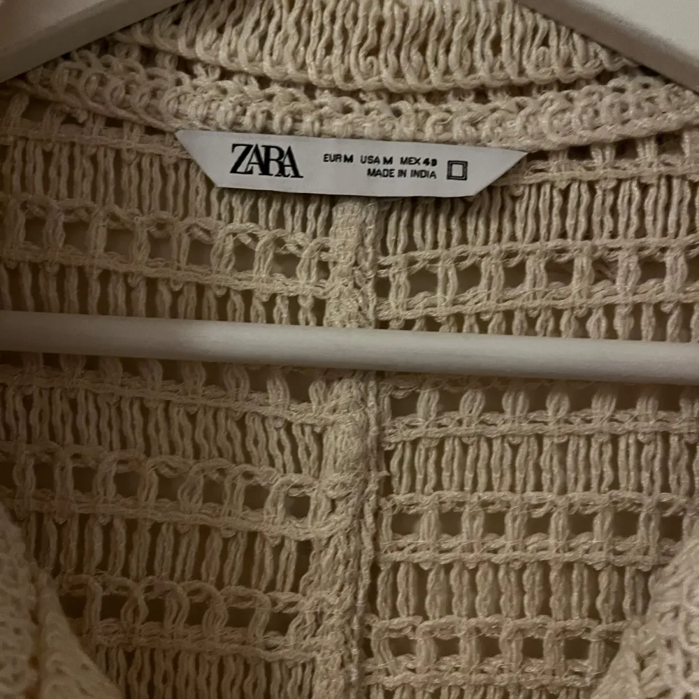 Säljer en superfin beige stickad skjorta från Zara. Den har korta ärmar och ett snyggt mönster med hålstickning som ger en luftig känsla. Perfekt för sommarens varma dagar eller som ett lager under hösten. Skjortan är i mycket bra skick och passar både till vardags och fest! 🌟 Nyskick.. Neuleet.
