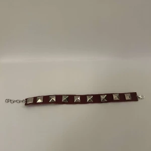 Armband med nitar  - Snyggt armband med fyrkantiga. Armbandet har en justerbar kedja för perfekt passform. Perfekt för att ge en edgy touch till din outfit. Passar till både killar och tjejer!