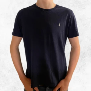 Mörkblå Polo Ralph Lauren T-shirt  - Säljer denna riktigt snygga marinblåa T-shirten från Polo Ralph Lauren. Säljer även 3 andra liknande t-shirts i min profil. Vid några frågor eller funderingar är det bara att höra av sig.