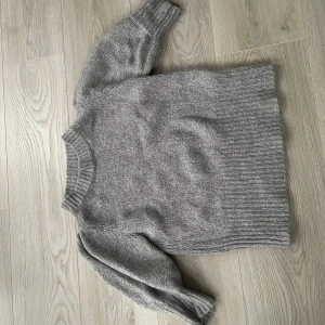 Grå stickad tröja från NA-KD - Säljer en stilren grå stickad t-shirt från nakd. Använd ett fåtal gånger✨ pris kan diskuteras
