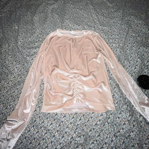 Ljus rosa sammetstopp från Zara - Säljer en elegant ljus rosa sammetstopp från Zara med långa ärmar och en snygg rynkdetalj framtill. Perfekt för en stilren look. Passar storlek 11-12 år.