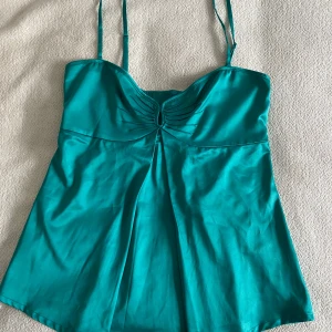 Turkost linne - Snygg turkos linnetopp med smala axelband och rynkdetalj framtill. 