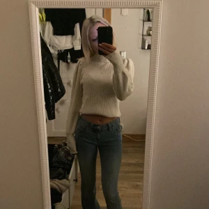 Vit ribbad croppad tröja - Säljer en stilren vit ribbad tröja med croppad passform. Tröjan har långa ärmar och är perfekt för en trendig look. Passar bra till jeans eller kjol för en avslappnad stil.