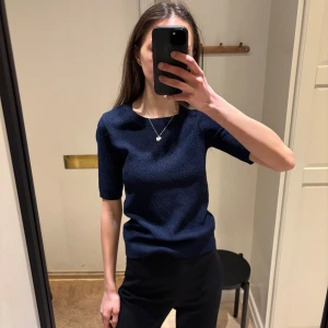 Mörkblå tröja från Stockhlm - Snygg mörkblå tröja från Stockhlm med korta ärmar och ett diskret mönster. Perfekt för en stilren look. 