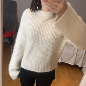 Vit stickad tröja från H&M Divided - Mysig vit stickad tröja från H&M Divided. Tröjan har en avslappnad passform med långa ärmar och en rund halsringning. Perfekt för kyligare dagar.