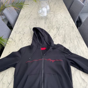 Svart zip hoodie från hugo boss - Säljer en skön hugo boss zip hoodie då den är för liten för mig.