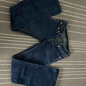 Mörkblå jeans från Levi's - Snygga mörkblå jeans från Levi's med klassisk design och fem fickor. De har en knappgylf och kontrastsömmar som ger en stilren look. Perfekta för en avslappnad stil. Säljer då de inte passar längre. Pris kan diskuteras.