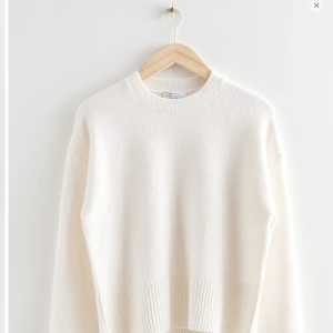 Vit stickad tröja från & Other Stories - Säljer en stilren vit stickad tröja från & Other Stories. Tröjan har en rund halsringning och långa ärmar med ribbade muddar vid ärmslut och nederkant. Perfekt för kyligare dagar. 🧶