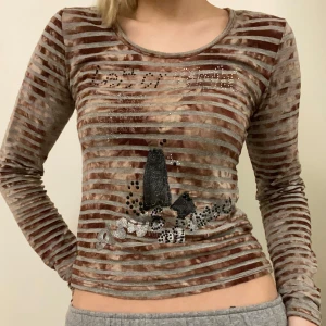 Cool randig topp - Unik brun och grå randig långärmad tröja. Den är i bra skick då jag aldrig använt den. Säljer dessutom en liknande i svart, båda är köpta för 300 kr. Perfekt för dig som vill sticka ut med en annorlunda stil. Hör av dig om du har några frågor :)