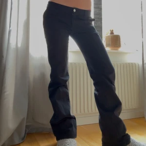 Svarta bootcut jeans - Snygga svarta bootcut jeans med låg midja. Perfekta för en avslappnad stil. De har en klassisk design med knappar och dragkedja framtill.
