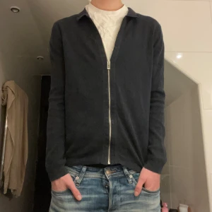 Full zip tröja från primark - Säljer en stilren svart tröja från primark med dragkedja framtill. Tröjan har långa ärmar och en klassisk krage, perfekt för en avslappnad men ändå elegant look. Tröjan är köpt i london och tillverkas ej längre.Xs men passar även S.  Tveka inte att kontakta vid minsta fråga!  Pris går att diskutera!