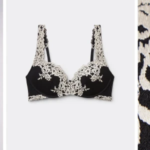 Svart spetsbehå med broderade detaljer - Elegant svart behå med vackra broderade spetsdetaljer i kontrasterande färg. 