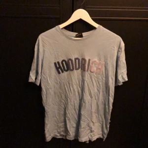 Ljusblå t-shirt från Hoodrich - Säljer en ljusblå t-shirt från Hoodrich med tryck på framsidan. Säljer då jag inte använder den. Storlek small.