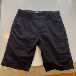 Svarta shorts från WND - Snygga svarta shorts från WND med dragkedja på sidan. Perfekta för en avslappnad stil. De har en normal passform och är tillverkade i ett bekvämt material.
