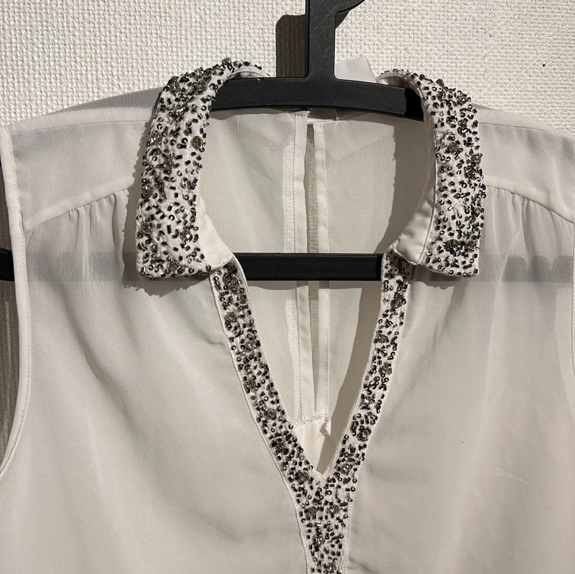 Vit ärmlös blus med pärldetaljer - 1