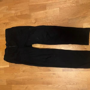 Svarta chinos byxor från H&M - Säljer ett par svarta slim fit byxor från H&M i storlek EUR 164. De har justerbar midja för perfekt passform. Perfekta för både vardag och fest! 🖤