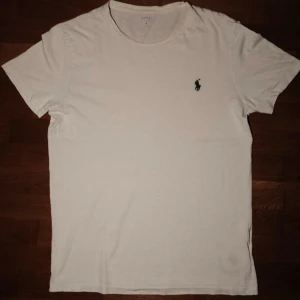 Vit Ralph Lauren T-Shirt  - Säljer nu min sjukt snygga Ralph Lauren T-Shirt. Skick 8/10, loggan i nacken sliten (se bild 3). Storlek S passar 180~. Hör av dig om du undrar något eller vill ha fler bilder!