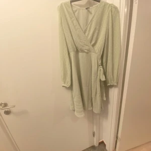 Ljusgrön omlottklänning från Vero Moda - Säljer en superfin ljusgrön omlottklänning från Vero Moda i storlek S. Klänningen har långa ärmar och ett diskret prickigt mönster. Perfekt för vår och sommar! 💚