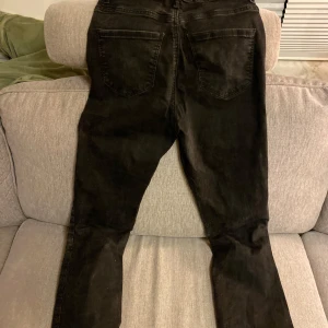 Svarta jeans från Vero Moda - Säljer ett par svarta jeans från Vero Moda i storlek 27/32. De är i bra skick och har en klassisk femficksdesign med knapp och dragkedja framtill. Perfekta för både vardag och fest!