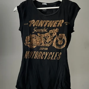T-shirt med tryck. - Grå T-shirt med orange tryck.