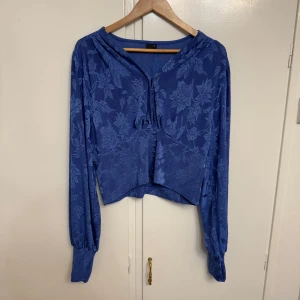 Blå blommig topp från Gina Tricot - Säljer en superfin blå topp från Gina Tricot i storlek XL men skulle även passa en L. Den har ett subtilt blommönster och långa ärmar med en lite lösare passform. Perfekt för både vardag och fest! 💙