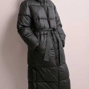 Lång jacka med bälte - Säljer en supermysig svart lång dunjacka som är perfekt för kalla vinterdagar. Den har ett bälte i midjan för en snygg passform. Jackan har en dragkedja framtill och är andvänd ett fåtal gånger under förra vintern🩷Nypris 999kr, kom gärna med förslag!