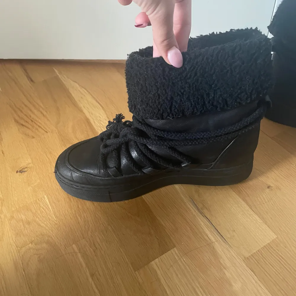 Säljer ett par svarta boots i skinn med mysig pälsdejtalj runt skaftet. Det har snörningar framtill och är varma och sköna ut för vintern. . Skor.