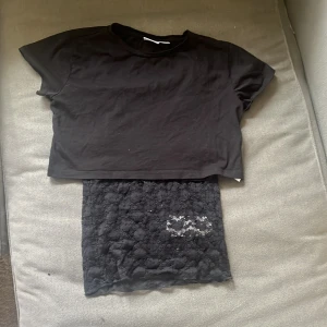 Svart croppad topp och spetslinne från Gina Tricot Gina Tricot - Säljer en svart croppad topp och ett svart spetslinne från Gina Tricot. Den croppade toppen är kortärmad och perfekt för en avslappnad stil. Spetslinnet är ärmlöst och har ett elegant mönster. Perfekt för lager-på-lager look! Säljer dom som ett kitt men går att köpa en och en!