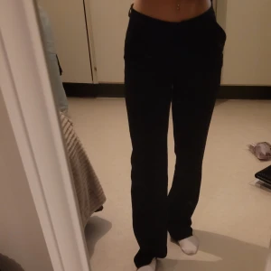 Svarta kostymbyxor i storlek XS - Säljer ett par svarta kostymbyxor i storlek XS. Dom är midwaist och har en straight passform som ger en stilren look. Perfekta för både vardag och fest! Byxorna är i bra skick och har en knappdetalj framtill. (Bara att skriva om ni vill ha mer bilder)