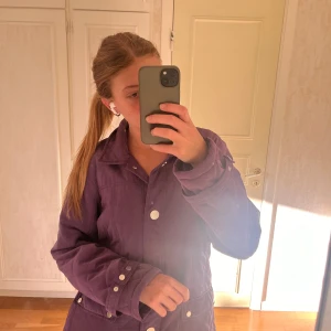 Lila jacka från Emm - Säljer en snygg lila jacka från Emm i storlek 42. Jag har vanligtvis s och passar för mig. Jackan har långa ärmar och knappar framtill. Perfekt för höst och vår med sin stilrena design. Den är i mycket bra skick💘