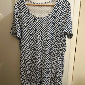 Mönstrad klänning från Esmara - Säljer en snygg mönstrad klänning från Esmara i storlek XL. Den har ett coolt geometriskt mönster i blått och vitt. Perfekt för både vardag och fest! Klänningen har korta ärmar och en bekväm passform.
