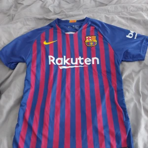 FC Barcelona tröja - Säljer en FC Barcelona tröja med Messi 10 på ryggen. Den är blå och röd med ränder och har korta ärmar. Märket är Nike och den är i Dri-FIT material, perfekt för fotbollsträning eller att heja på laget. Storleken är 164, vilket passar bra för ungdomar. Lite mörkare färger än på bilden :)