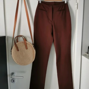 Low waist vintage retro united colors of benetton kostymbyxa 38 - Vad : Y2k vibe  low waist United colors of benetton bruna byxor.  Material : 100% polyester  Storlek : 38 Skick : Mycket fint skick utan defekter  Mått : midja 32-34 cm x 2 töjer, beninnerlängd 74 cm, hela byxans längd 100 cm bak, 96 cm fram