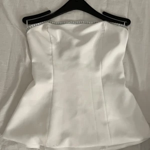 Vit tube topp med silver detaljer - Jättesnygg att styla nu till halloween med accessoarer!!! Storlek Xs men passar även S skulle jag säga. Supersnygg på! Postar samma dag så det hinner komma fram till halloween. Köpt på zara för typ 400kr. Aldrig använd!💞💞💞