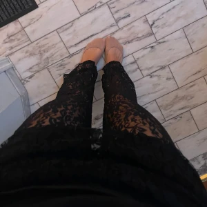 Svarta spetsbyxor - Säljer ett par snygga svarta spetsbyxor som är perfekta för fest. Vida i benen. Byxorna är genomskinliga med ett vackert spetsmönster och har en elastisk midja för extra komfort. Perfekta att styla med en enkel topp och klackar för en kväll ute!