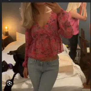 Säljer en superfin rosa blommig blus med v-ringning och långa ärmar. Perfekt för både vardag och fest! Passar perfekt till jeans eller kjol för en söt outfit🤍💗