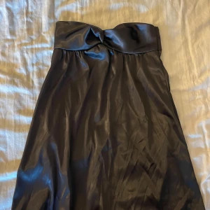 Satin festklänning - En snygg och elegant fest klänning i satin! En rak bandoue klänning som har en fin design över bröstet. Skulle säga att klänningen är i storlek XS. Säljer den snygga klänningen på grund utav att den var för liten.