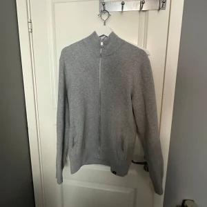 Grå tröja  - Säljer en grå zip tröja som jag köpte i England. Använt ett par gånger men finns inget tecken på användning! Passar ca 180-185 