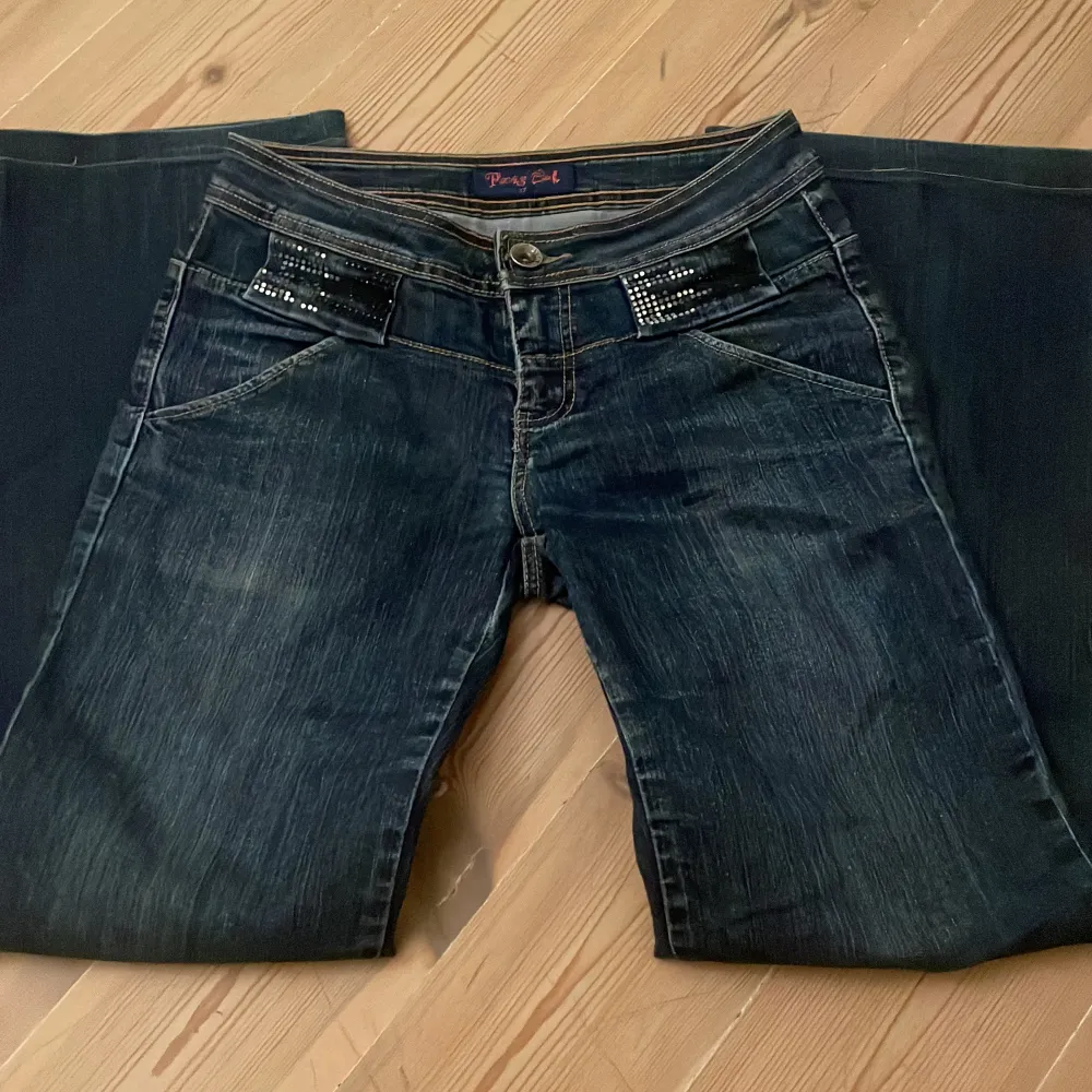 Säljer ett par snygga mörkblå utsvängda jeans med coola paljettdetaljer på fickorna. Köpte här på plick men var tyvärr för stora 💓 Midjemått:36  Innerben: 79 . Jeans & Byxor.