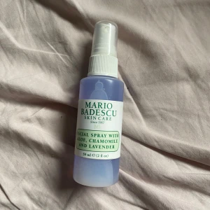 Mario Badescu Facial Spray - Säljer en ansiktsspray från Mario Badescu med aloe, kamomill och lavendel. Flaskan är 59 ml och har en praktisk sprayfunktion. Perfekt för att fräscha upp huden under dagen eller som en del av din hudvårdsrutin. Den har en lugnande doft av lavendel och är lätt att ta med sig i väskan.