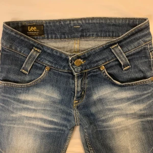 Lågmidjade lee jeans - Säljer dessa skitsnygga jeansen från lee. Midjemått tvärs över: ca 35 cm, innebenslängd: ca 75 cm. De är i väldigt bra skick, dock har sömmen där man stänger knappen gått upp lite (se bild 4). Skriv om frågor eller bilder💕💕