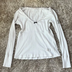 odd molly tröja - vit långärmad odd molly tröja med svart rosett, storlek 0 vilket motsvarar xs, men skulle säga att den även passar s, köpt second hand men bra skick & aldrig använd av mig💓