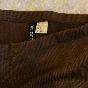 Brun glitterkjol från H&M😍😍 - Snygg brun höstkjol med slits och glitter!! Kan stylas både upp och ner beroende på tillfälle. Den har även ett långt band fram som är tänkt att knyta runt magen något varv. Men går ju utmärkt att klippa av dessa om man vill det 😍😍 knappt använd!!!!!