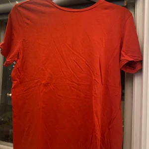 Röd t-shirt i ekologisk bomull - Säljer en enkel och stilren röd t-shirt i ekologisk bomull. Perfekt för vardagsbruk med en skön passform. Kortärmad och i storlek M. Passar till alla tillfällen!